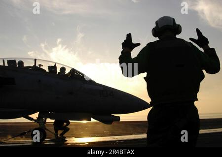 US Navy ein Petty Officer leitet eine F-14 Tomcat bis zum Katapult im Cockpit an Bord des Flugzeugträgers USS Theodore Roosevelt (CVN 71) der Nimitz-Klasse. Stockfoto