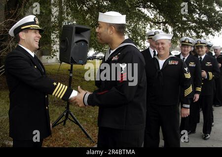 DIE Mate 1.-Klasse DER US Navy Gunner gratuliert und verabschiedet sich von Captain, der seinen Kommandowechsel beendet Stockfoto