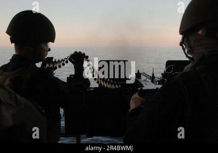 US Navy Gunner's Mate 3. Klasse füttert 50 Kal. Runden für His für Aviation Ordnanceman 3. Klasse Stockfoto