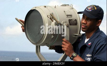 US Navy Quartermaster 2. Klasse sendet ein Blitzsignal an den gesteuerten Raketenzerstörer USS Carney (DDG 64). Stockfoto