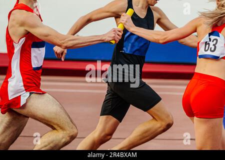 Gemischte Leichtathletik- und Feldmannschaften, die ein Staffelrennen von 4 x 400 Metern in den Sommersportmeisterschaften absolvieren Stockfoto