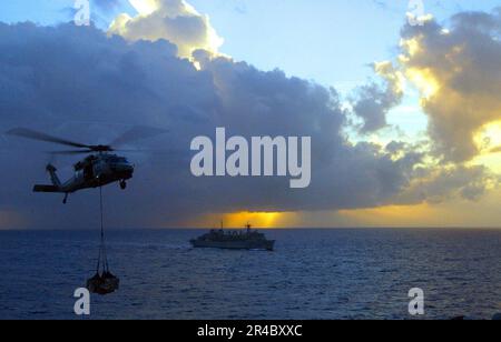 US Navy ein MH-60s Seahawk Helikopter liefert Lieferungen während einer vertikalen Auffüllung (VERTREP). Stockfoto