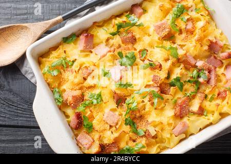 Cremige gebackene Pasta mit Speck und Käse auf dem Backblech auf dem Tisch. Horizontale Draufsicht von oben Stockfoto