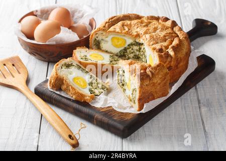 Torta Pasqualina typische salzige osterkuchen-Spezialität in liguria Torta Nahaufnahme auf dem Holzbrett auf dem Tisch. Horizontal Stockfoto