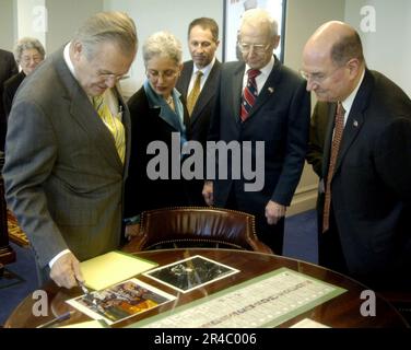 US Navy Secretary of Defense (SECDEF), der ehrenwerte Donald H. Rumsfeld, Linke, und der Marineminister (SECNAV), der ehrenwerte Dr. Donald C. Winter, rechts, schauen Sie sich mehrere Artefakte in Rumsfelds Offi an. Stockfoto