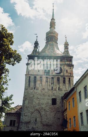 Eine imposante Ziegelstruktur mit mehreren Fenstern und einem auffälligen Turm an der Seite Stockfoto