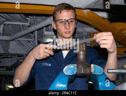 US Navy Machinery Repair Monteur 3. Class feuert einen Bolzen von einer wasserdichten Luke an Bord des Flugzeugträgers USS Dwight D. Eisenhower (CVN 69) der Nimitz-Klasse. Stockfoto