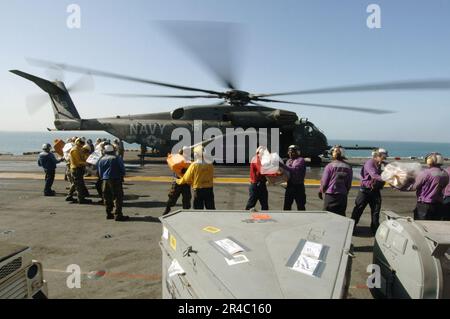 US Navy-Matrosen und Marines entladen Post und Fracht von einem MH-53E Sea Dragon Hubschrauber, der der Blackhawks of Helicopter Mine Counter Measure Squadron One Five (HM-15) zugeteilt wurde. Stockfoto