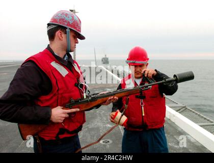 US Navy Gunner's Mate 3. Class und Gunner's Mate 1. Class bereiten Sie eine Schusslinie für eine Nachschub vor Stockfoto