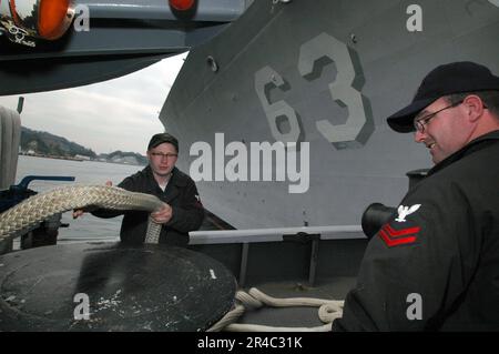 US Navy Engineman 1. Class und Boatswain's Mate 2. Class werden in Reihe geschleppt, während sich das Schlepper USS Manistee (YTB 782) darauf vorbereitet, dem Guided-Missile Cruiser USS Cowpens (CG 63) zu helfen Stockfoto