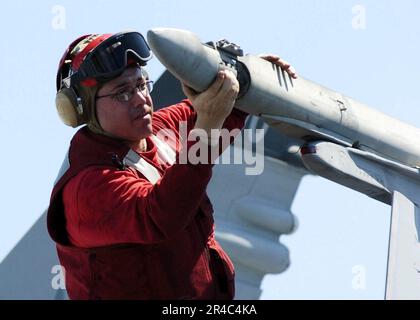 US Navy und Aviation Ordnanceman überprüfen eine F-A-18C Hornet vor dem Flug. Stockfoto