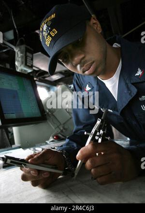 US Navy Quartermaster Klasse 3., der dem Zerstörer USS Stethem (DDG 63) zugeteilt ist, plant den Kurs des Schiffes. Stockfoto