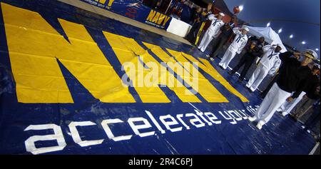 COMMANDER der US Navy, Rekrutierungskommando der Navy, Konteradmiral Jeffrey Fowler salutiert die Farben während des Spiels der Nationalhymne. Stockfoto