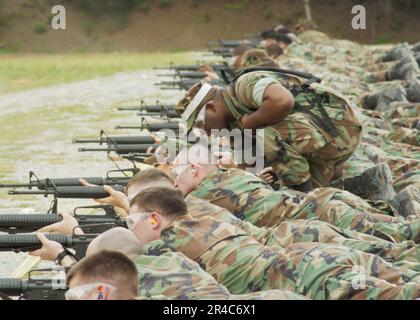 US Navy Construction Mechanic 2. Class unterstützt Mitglieder des Naval Mobile Construction Battalion Four (NMCB-4) mit ihren M-16-Dienstgewehren während der Waffenqualifizierung. Stockfoto