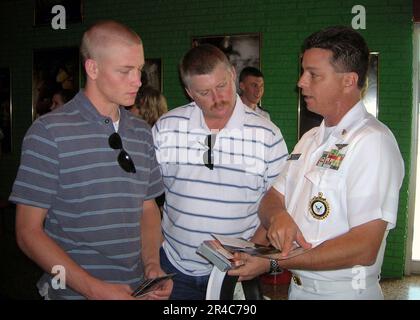 US Navy Senior Chief Aviation Maintenance Administrationman erklärt einem Schüler und seinem Vater die NROTC-Programmoptionen zur Unterstützung der Navy Week Dallas. Stockfoto