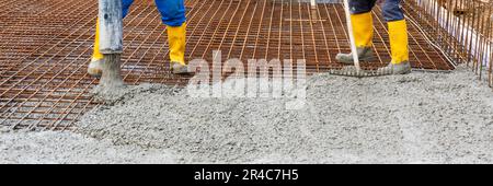 Der Arbeiter betreibt das Fundament eines Hauses Stockfoto