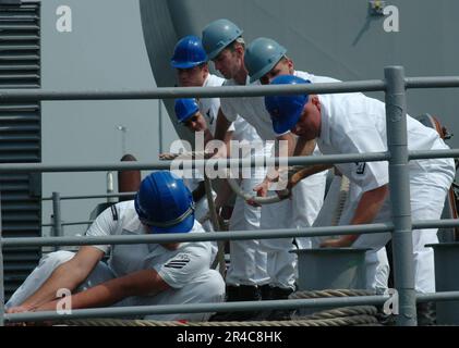 US Navy Line Handler an Bord des Guided-Raketen-Cruisers USS Monterey (CG 61) verlegen das Schiff auf dem Pier, wenn es zur Naval Station Norfolk zurückkehrt. Stockfoto