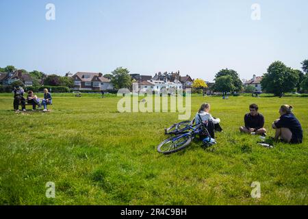 London UK. 27. Mai 2023 Personen, die sich im Sonnenschein auf dem Wimbledon Common, Südwesten Londons, entspannen. Wettervorhersagen sagen sagen Sonnenschein mit warmen Temperaturen, die über das Feiertagswochenende Höchsttemperaturen von 24 grad celsius erreichen. Kredit: amer Ghazzal/Alamy Live News Stockfoto