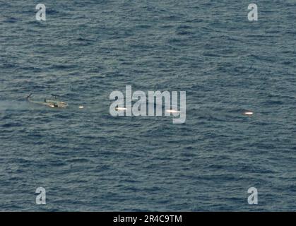 US Navy ein AH-1W Super Cobra, der den Flying Tigers of Marine Medium Helicopter Squadron Two Six Two (HMM-262) zugeteilt wurde, startet 2,75-Zoll-Raketen. Stockfoto