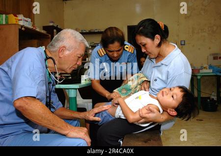 US Navy ein Arzt bei Aloha Medical Mission und Commander. Diviya Gautam von der indischen Marine untersucht einen Jungen im Camp Batista während eines medizinischen und zahnärztlichen Zivilaktionsprojekts auf Diagnosen. Stockfoto