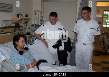 US Navy Hospital Corpsman 2. Klasse und Boatswain Mate 3. Klasse sprechen mit einem Patienten während eines Besuchs im Dornbecher Shrinners Kinderkrankenhaus. Stockfoto