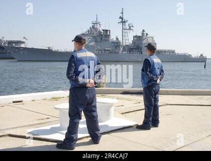 US Navy Quartermaster 2.-Klasse und Boatswain's Mate 3.-Klasse, bereit zum Anlegen des geführten Raketenkreuzers USS Vicksburg (CG 69). Stockfoto