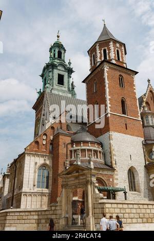 Zwei Personen stehen vor einem traditionellen Kirchengebäude mit zwei spitzen Türmen und einer Uhr oben Stockfoto