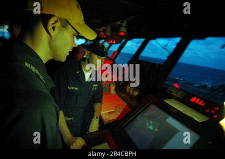 US Navy LT. Weist Fähnrich als Wachoffizier auf der Brücke an Bord des konventionell angetriebenen Flugzeugträgers USS Kitty Hawk (CV 63) zu. Stockfoto