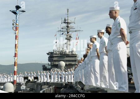 DER konventionell angetriebene Flugzeugträger USS Kitty Hawk (CV 63) DER US Navy bemannt die Schienen, während das Schiff in Otaru einläuft, während eines planmäßigen Hafenbesuchs. Stockfoto