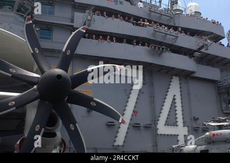 US Navy-Matrosen versammeln sich auf der Inselstruktur des Flugzeugträgers der Nimitz-Klasse USS John C. Stennis (CVN 74), um eine Demonstration der Luftkraft von Carrier Air Wing Nine (CVW-9) zu beobachten. Stockfoto