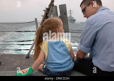 US Navy Information Systems Technician sitzt mit seiner kleinen Schwester auf einer eintägigen Kreuzfahrt mit Familie und Freund an Bord der Fregatte USS Carr (FFG 52). Stockfoto