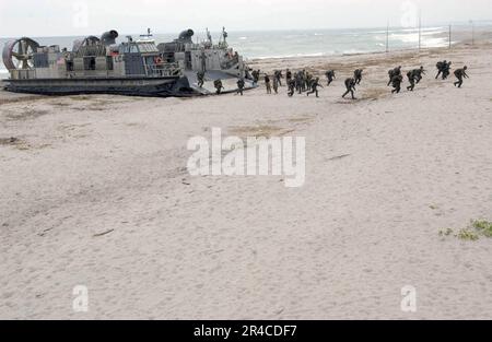 US Navy Philippine Marines entbark das Landungsschiff Air Cushion Five Seven (LCAC 57) aus Assault Craft Unit 5 während eines Kampfes-Kampfkooperation über Wasser, Bereitschaft und Training (CARAT), einem amphibischen Angriff vom Dock lan. Stockfoto