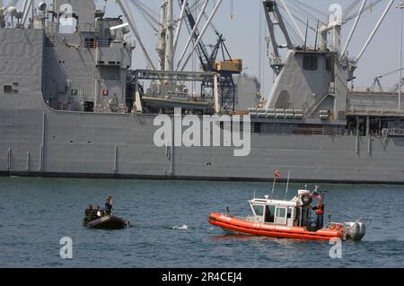 US Navy USA Küstenwachmänner, die dem Maritime Safety Security Team (MSST) 91103 zugewiesen sind, verwenden die integrierte Schwimmschutzausrüstung mit Tauchern im Wasser während der Übung Seahawk 2006. Stockfoto