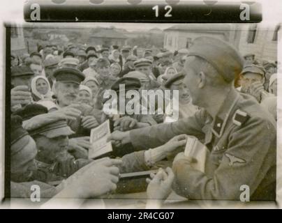 Der SS-Fotograf Ahrens nimmt die Intensität und Brutalität der Kavallerie-Operationen in Russland im Mai und Juni 1943 auf und bietet durch seine Linse einen gespenstischen Einblick in die düsteren Realitäten des Krieges. Hochrangige Offiziere in Kleideruniformen mit Auszeichnungen, verwundete Soldaten im Kriegskrankenhaus; Soldaten mit russischen Zivilisten; Preisverleihungen, Landschaften, Sägewerk, Terrain-Tisch-Übungen, Kampfpositionen, Soldaten entspannen und schwimmen, Infanterie-Truppentraining, Propagandamaterial, das an russische Zivilisten verteilt wird, brennendes Dorf, Sturmgewehreinheit, Kasernen-Szenen. Dargestellte Bilder Stockfoto