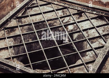 Nahaufnahme des alten Wasserstrahls mit dem Eisengitter. Straßenszene. Hochwertige Bilder für Tapeten, Reise-Blogs, Zeitschriften, Artikel Stockfoto