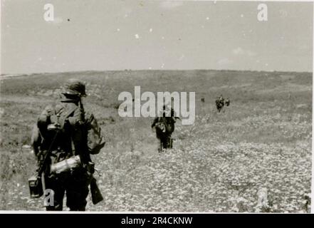 SS-Fotograf Willi Altstadt, Wiking Division, Russland 1942. Dorfszenen in der Gegend von Rostow, ein Panzer III (mit Einheitensymbolen) und panzer Grenadier auf der Steppe, Kampfszenen entlang eines Flusses, Nahaufnahmen der Infanterie auf dem Feld mit individuellen und Besatzungswaffen, eine Flussüberquerung (Überfall und Pontonflöße), Bau eines Straßenblocks, russische Kriegsgefangene, SS-Soldaten zum Angeln und Schwimmen, Zeremonie der Einheiten, Beobachtungsposten mit Blick auf einen Fluss und schwere Artilleriecrew mit Haubitzen. Bilder, die die Front-Front-Aktivitäten der Waffen-SS-Einheiten an der westlichen und östlichen Front zeigen, i. Stockfoto