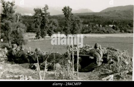 SS-Fotograf Willi Altstadt, Wiking Division, Russland 1942. Dorfszenen in der Gegend von Rostow, ein Panzer III (mit Einheitensymbolen) und panzer Grenadier auf der Steppe, Kampfszenen entlang eines Flusses, Nahaufnahmen der Infanterie auf dem Feld mit individuellen und Besatzungswaffen, eine Flussüberquerung (Überfall und Pontonflöße), Bau eines Straßenblocks, russische Kriegsgefangene, SS-Soldaten zum Angeln und Schwimmen, Zeremonie der Einheiten, Beobachtungsposten mit Blick auf einen Fluss und schwere Artilleriecrew mit Haubitzen. Bilder, die die Front-Front-Aktivitäten der Waffen-SS-Einheiten an der westlichen und östlichen Front zeigen, i. Stockfoto