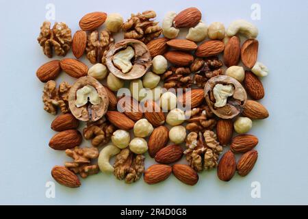 Ein Haufen geschälter Mandeln, Haselnüsse, Cashew und Walnüsse auf einem weißen Foto von oben Stockfoto