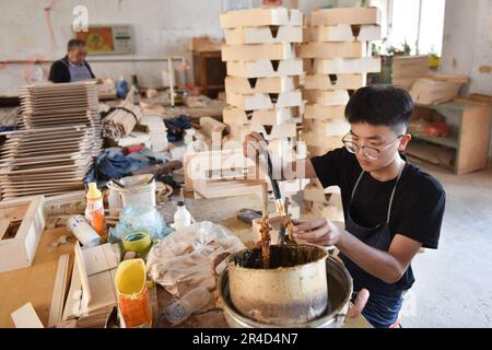 (230527) -- TIANJIN, 27. Mai 2023 (Xinhua) -- Ein Arbeiter produziert die Teile von Akkordeons in einer Werkstatt von Tianjin Yingwu Musical Instrument Co., Ltd. In Zhongwang, Stadt Jinghai, Nordchina Tianjin, 25. Mai 2023. Tianjin Yingwu Musical Instrument Co., Ltd. Ist ein Unternehmen mit einer 71-jährigen Geschichte in der Akkordeonherstellung. In den 1950er Jahren produzierte seine Vorgängerin Tianjin Musical Instrument Factory das erste Akkordeon im neuen China mit der Marke „Yingwu“. Von da an wurden die hier hergestellten Yingwu-Akkordeons zu Hause und im Ausland berühmt. In den letzten Jahren war das Unternehmen das Stockfoto