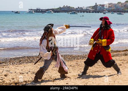 Swanage, Dorset, Großbritannien. 27. Mai 2023 Piraten erobern Swanage an einem warmen, sonnigen Tag zum Purbeck Pirate Festival. Ein unterhaltsamer Tag für die Massen. Piratenaktivitäten, Piratenparade und Scharmützel am Strand mit Nachstellung der Schlacht von Rotröcken gegen Piraten. Das Fest findet heute und morgen statt. Kredit: Carolyn Jenkins/Alamy Live News Stockfoto