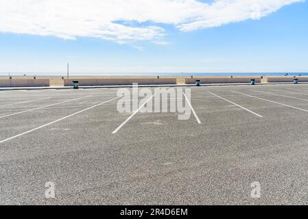 Leerer Parkplatz an einem Sandstrand an einem klaren, teilweise bewölkten Herbsttag Stockfoto