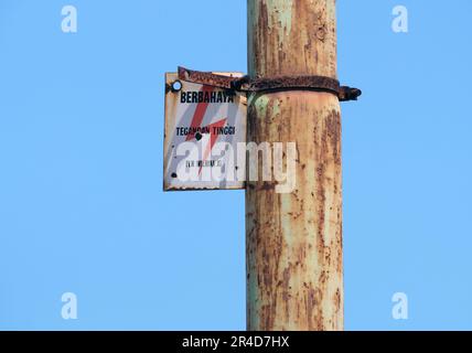 Warnschild Hochspannungsgefahr an elektrischen Polen Stockfoto