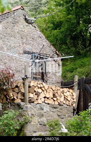 Rund um die Cheddar Gorge eine Touristenattraktion in Somerset, Großbritannien. Außerhalb eines Steinhauses gelagertes Feuerholz Stockfoto