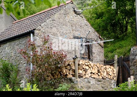 Rund um die Cheddar Gorge eine Touristenattraktion in Somerset, Großbritannien. Außerhalb eines Steinhauses gelagertes Feuerholz Stockfoto