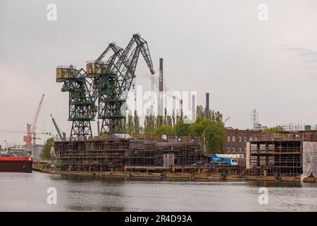 Danzig, Polen - 01. Mai 2019: Blick auf die Hafenkrane der kaiserlichen Werften. Schiffe liegen an der Anlegestelle. Stockfoto