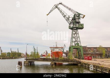 Danzig, Polen - 01. Mai 2019: Blick auf die Hafenkrane der kaiserlichen Werften. Schiffe liegen an der Anlegestelle. Stockfoto