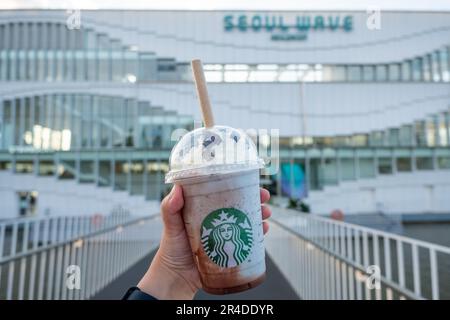 Seoul, Südkorea - 14. Juli 2022: Handgehaltener Becher Minzschokolade CIP, gemischt vor dem Seoul Wave Art Center Gebäude, schwimmendes Starbucks auf Ha Stockfoto