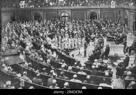 "Le General Pershing au Parlement Americain; devant le Senat et la Chambre des Representants reunis en Congres, a Washington, pour le recevoir, le 19 septembre 1919, le General Pershing, deabout au Centre de l'Hemicycle, expose l'Oeuvre accomplie par les armees americaines sur les champs de France; Des femmes et des enfants ont pris Place dans les travees parmi les membres du Congres', 1919. Aus „L'Album de la Guerre 1914-1919, Band 2“ [L'Illustration, Paris, 1924]. Stockfoto