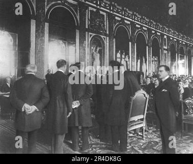 "La Signature du traite de paix a Versailles; Le Premier plenipotentiaire allemand, M Hermann Muller, ministre des Affaires etrangeres, signe le traite, le 28 juin 1919: Derriere lui, le Dr. Bell, second delegue, et trois Secretary allemands , Tours les cinq en redingote", 1919. Aus „L'Album de la Guerre 1914-1919, Band 2“ [L'Illustration, Paris, 1924]. Stockfoto