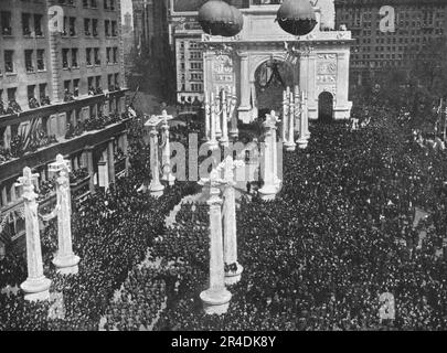 "Le Retour des Vainqueurs; Madison Square Pendant le defile de la 27e Division, la Premiere Formation americaine ramenee du Front francais: les pilastres sont surmontes de motifs allegoriques, Canon, Airplane au cuirasse et de ballons captifs", 1919. Aus „L'Album de la Guerre 1914-1919, Band 2“ [L'Illustration, Paris, 1924]. Stockfoto